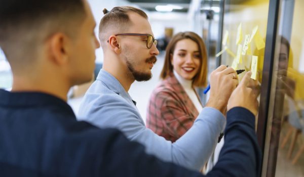 Young business people discussing and planning strategy Front of glass wall marker and stickers.